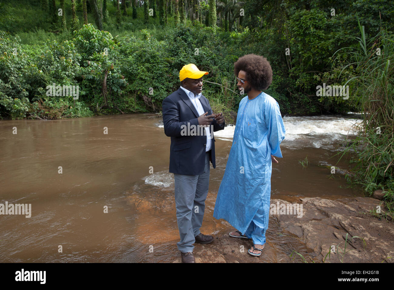 Dr Joseph Oye explains to footballer Benoit Assou-Ekotto, how river blindness is spread by a fly near fast-flowing rivers. Stock Photo