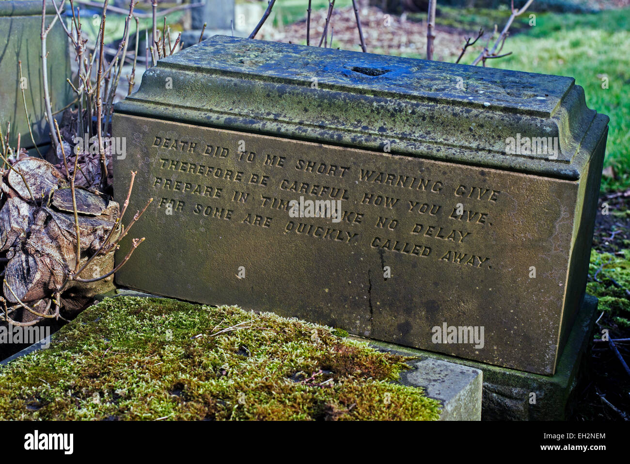 A derelict grave in a neglected graveyard, the sandstone plinth bears a ...