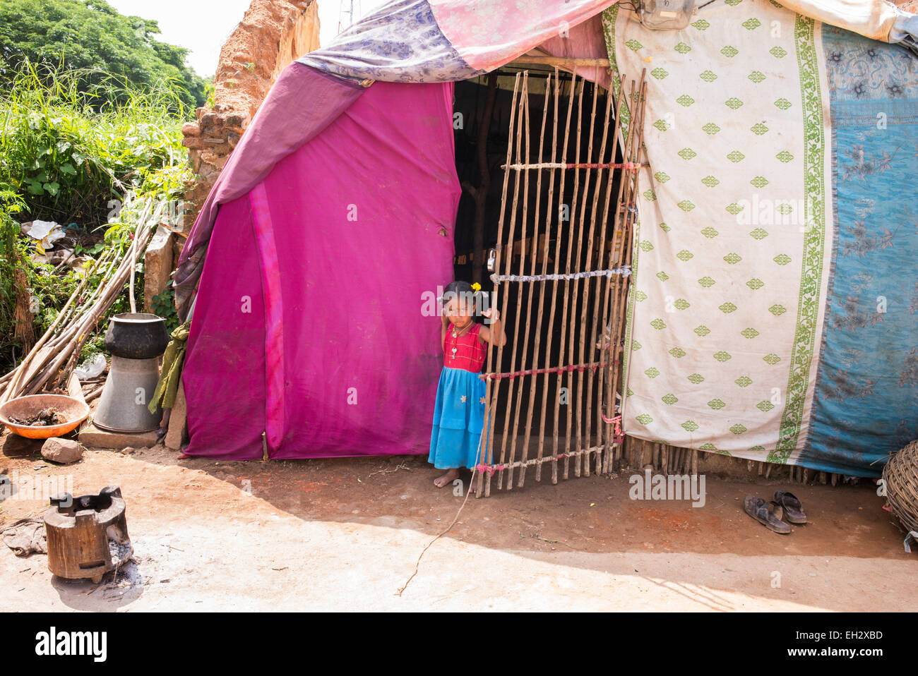 Poor indian lower caste girl behind gate of bender / tent / shelter.  Andhra Pradesh, India Stock Photo
