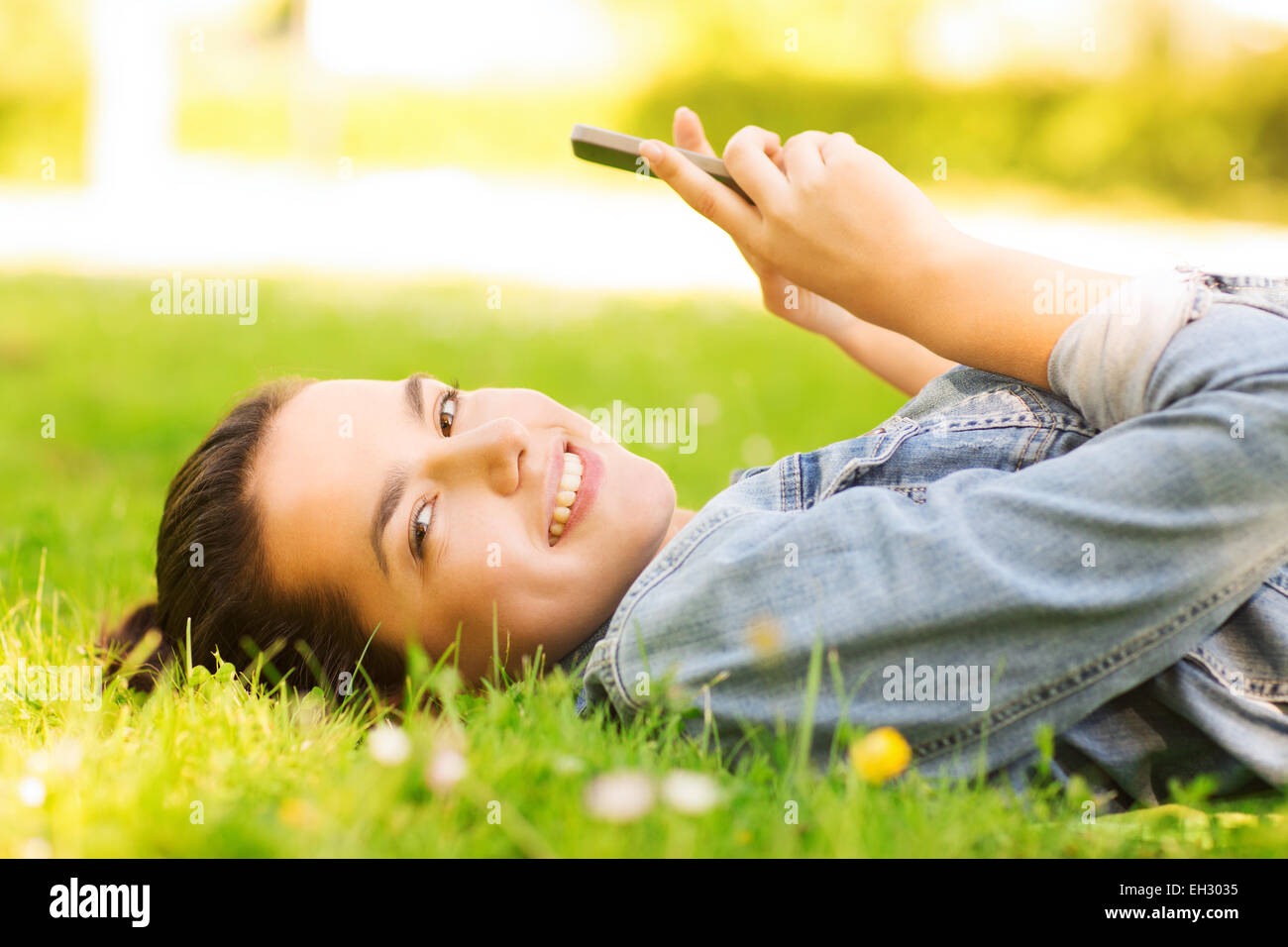 smiling young girl lying on grass Stock Photo - Alamy