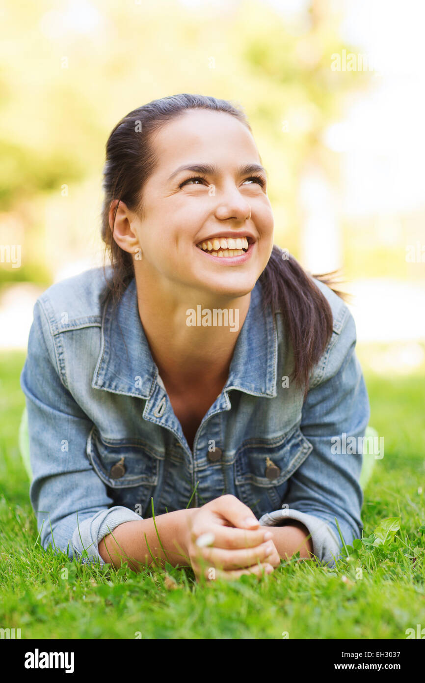 smiling young girl lying on grass Stock Photo - Alamy