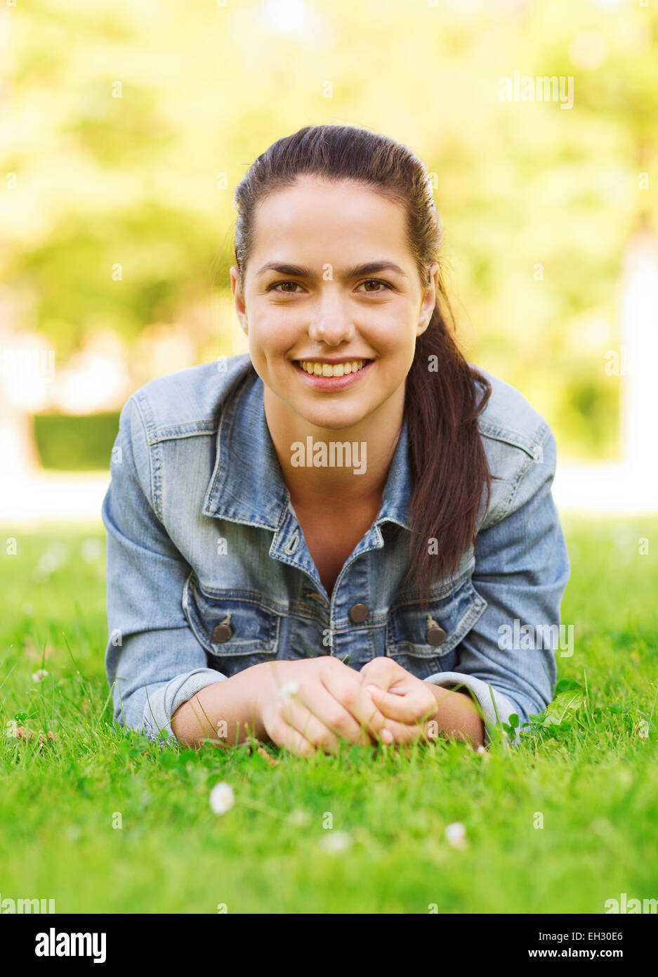 smiling young girl lying on grass Stock Photo - Alamy