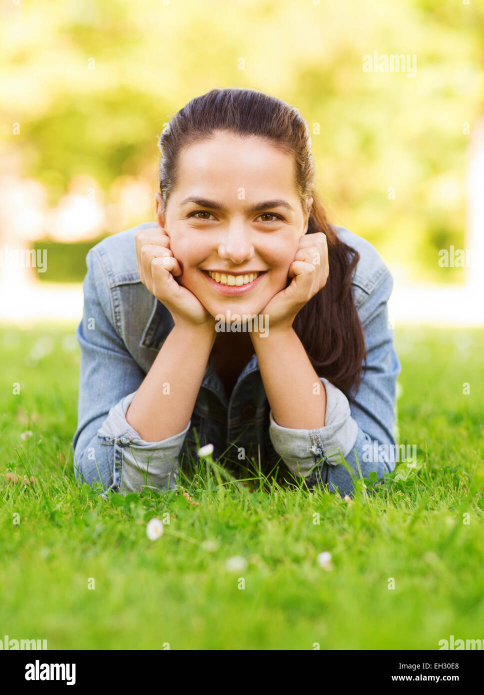smiling young girl lying on grass Stock Photo - Alamy