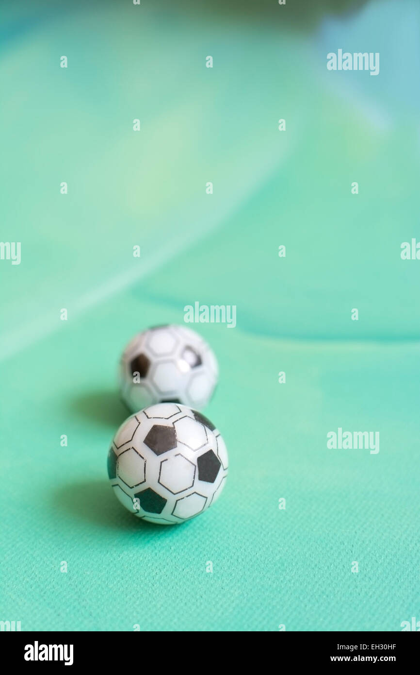 Toy soccer footballs on green canvas background. Stock Photo