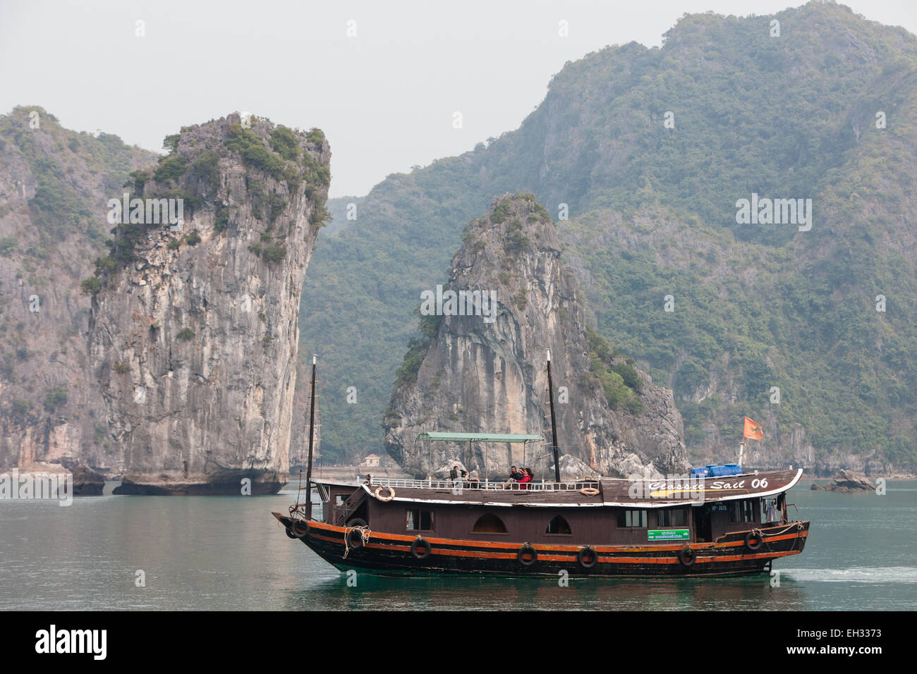 Junk, boat sailing amongst karst limestone mountains at Cat Ba National