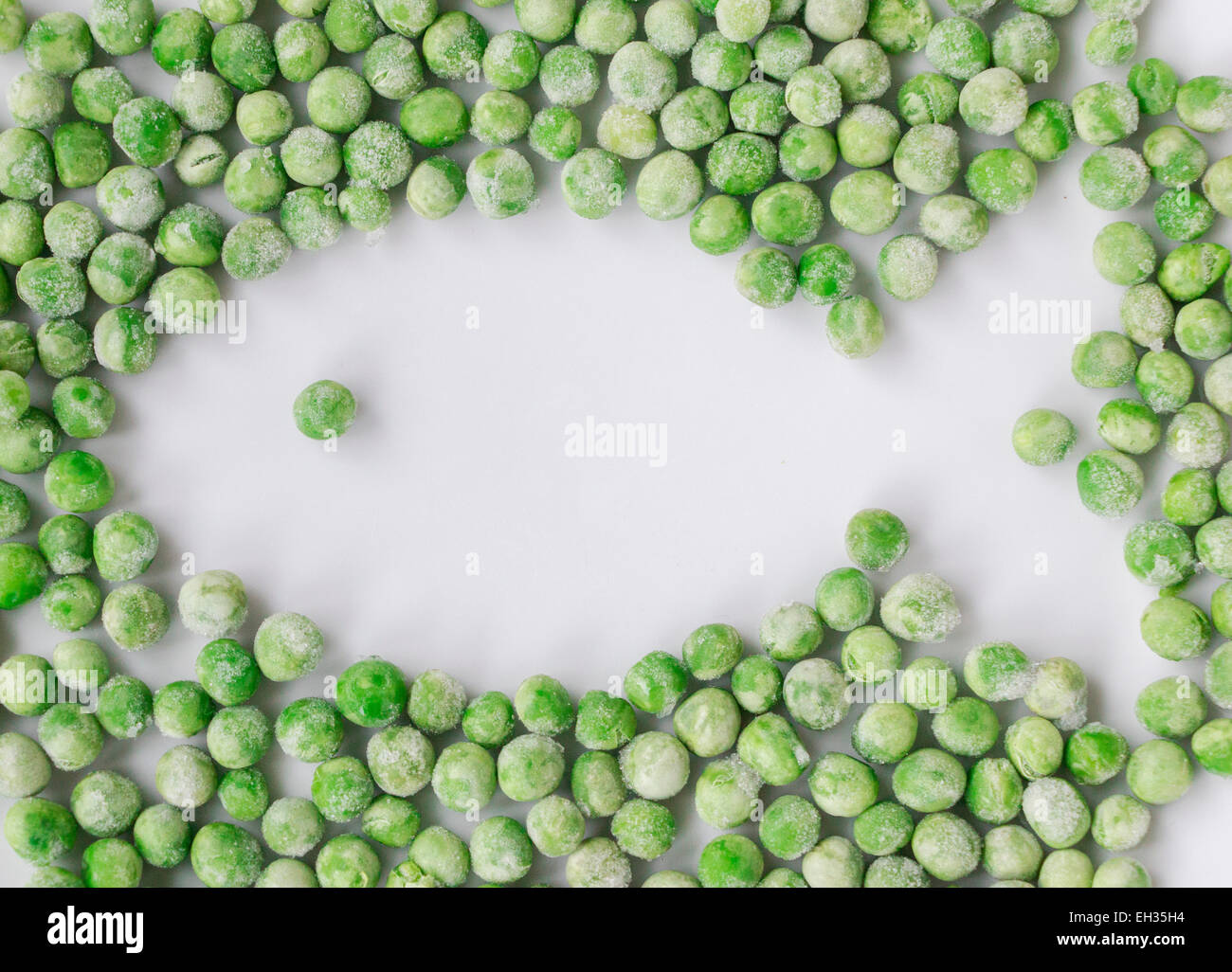 Garden peas leaving white space in a shape of a fish.  Fun food for kids. Endangered fish. Meatless food. Stock Photo