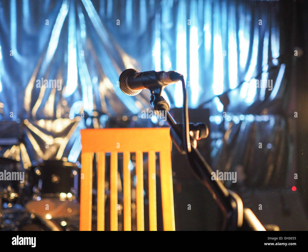 A microphone on an empty stage before a concert - selective focus on the mic with blurred background Stock Photo