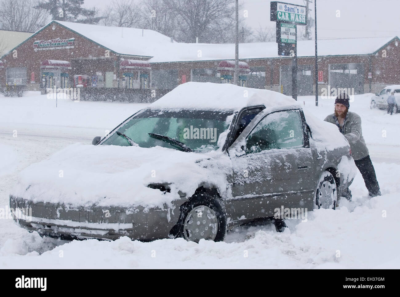 Lexington, Kentucky, USA. 05th Mar, 2015. A good Samaritan steers as an unidentified motorist pushes his car after getting stuck turning off New Circle Road into the Bryan Station Kroger shopping center on Thursday, March 5, 2015 in Lexington, KY, USA. The governor declared a statewide emergency for the second time in 17 days after a winter storm dumped up to 21 inches of snow on the state in less than 17 hours, including a new record of 17.1 inches in Lexington, Kentucky's second-largest city. (Apex MediaWire Photo by Billy Suratt) Stock Photo