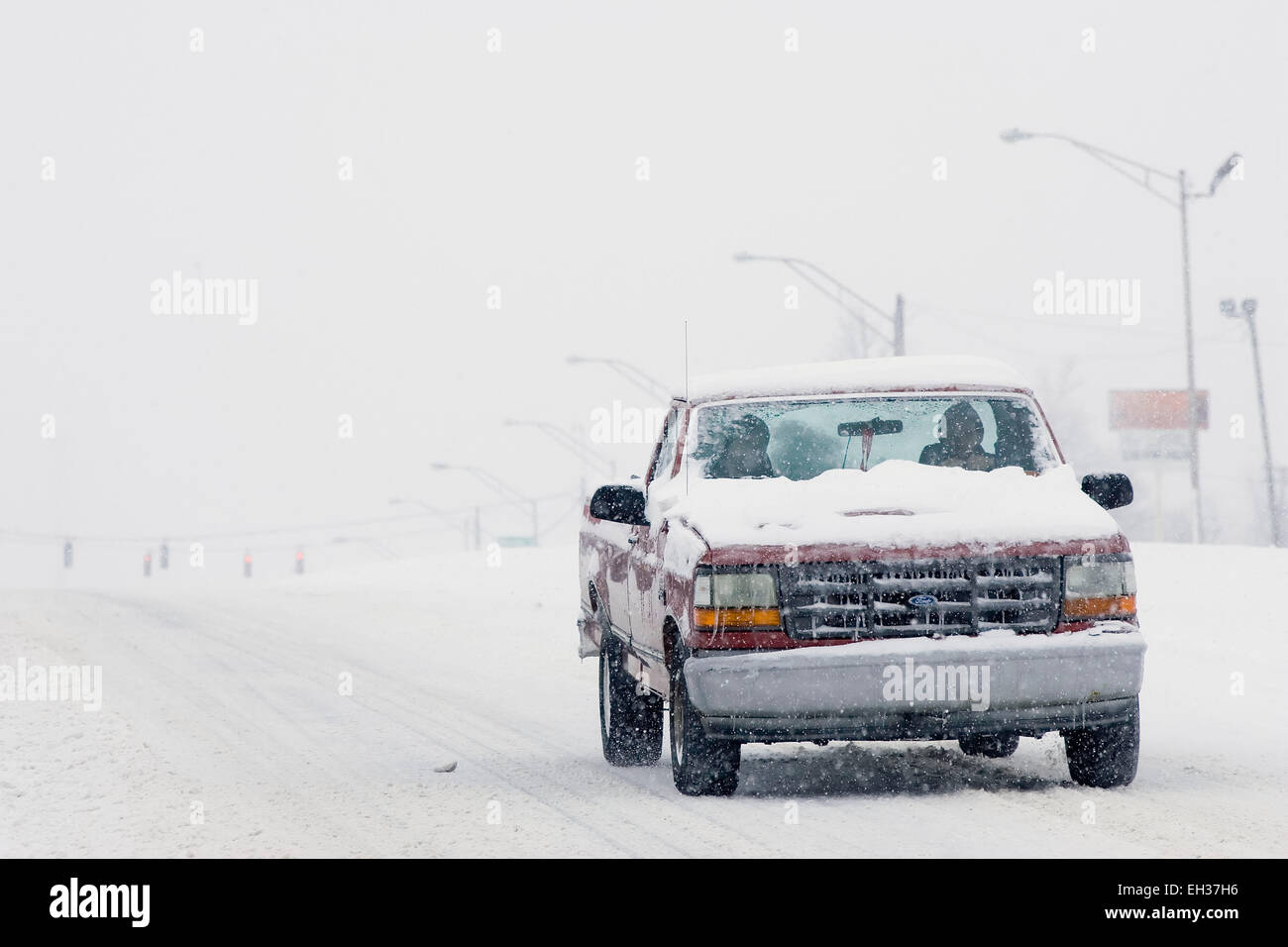 Lexington, Kentucky, USA. 05th Mar, 2015. A snow- and ice-covered Ford pickup truck traverses a whited-out New Circle Road, one of the city's main thoroughfares, as snow falls on Thursday, March 5, 2015 in Lexington, KY, USA. The governor declared a statewide emergency for the second time in 17 days after a winter storm dumped up to 21 inches of snow on the state in less than 17 hours, including a new record of 17.1 inches in Lexington, Kentucky's second-largest city. (Apex MediaWire Photo by Billy Suratt) Stock Photo