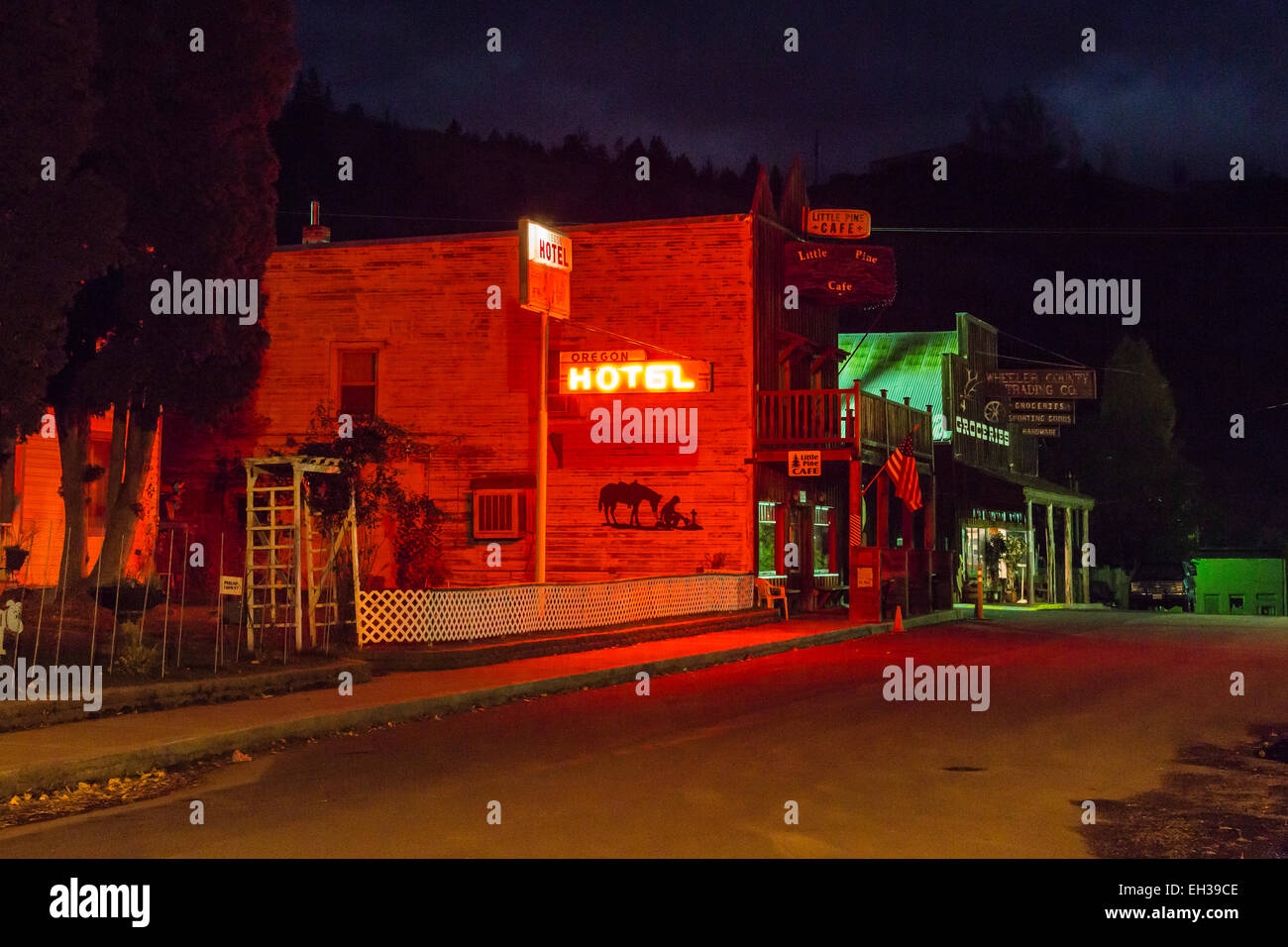 Classic western streetscape at night, with a neon Oregon Hotel sign