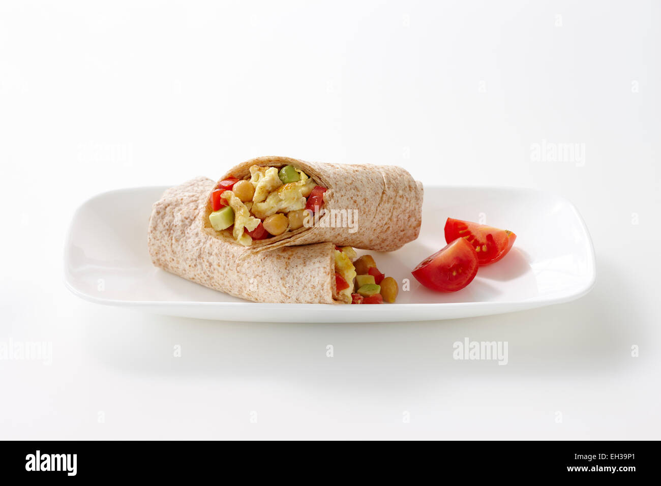 Breakfast Wrap made with Whole Wheat Tortilla filled with Egg, Chickpeas, Red Peppers and Avocado, Studio Shot Stock Photo