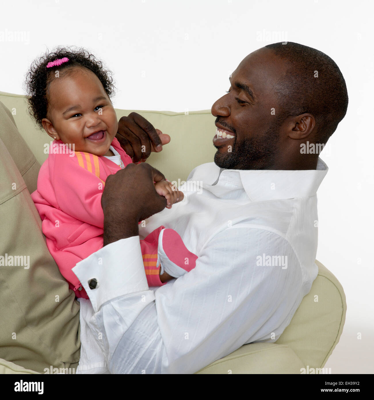 Portrait of Father and Baby Girl on Chair, Studio Shot Stock Photo