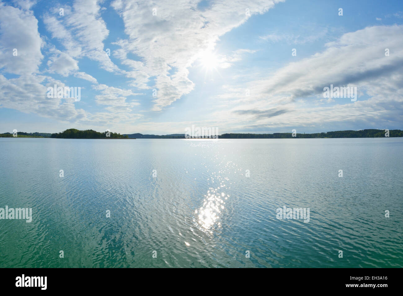 Blue sky, clouds and sun reflected in lake, Lake Woerthsee, Bavaria, Germany Stock Photo
