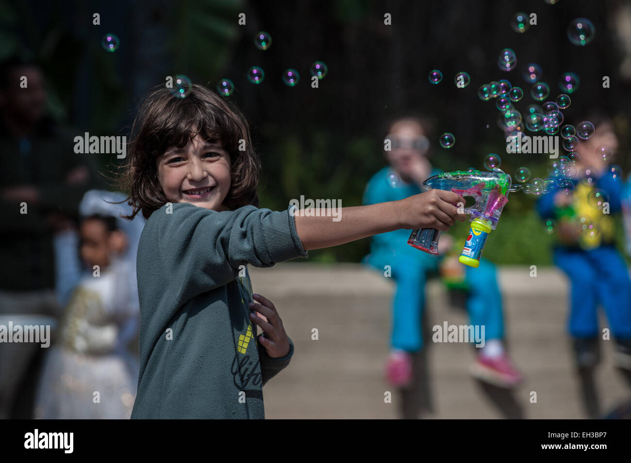 A child plays with bubbles during Adloyada Holon Purim Parade 2015 in Holon, central Israel, on March 5, 2015. The festive parade was held to celebrate Purim Thursday. Purim is a Jewish holiday that commemorates the deliverance of the Jewish people from Haman's plot during the reign of the ancient Persian Empire, according to the Biblical Book of Esther. Stock Photo