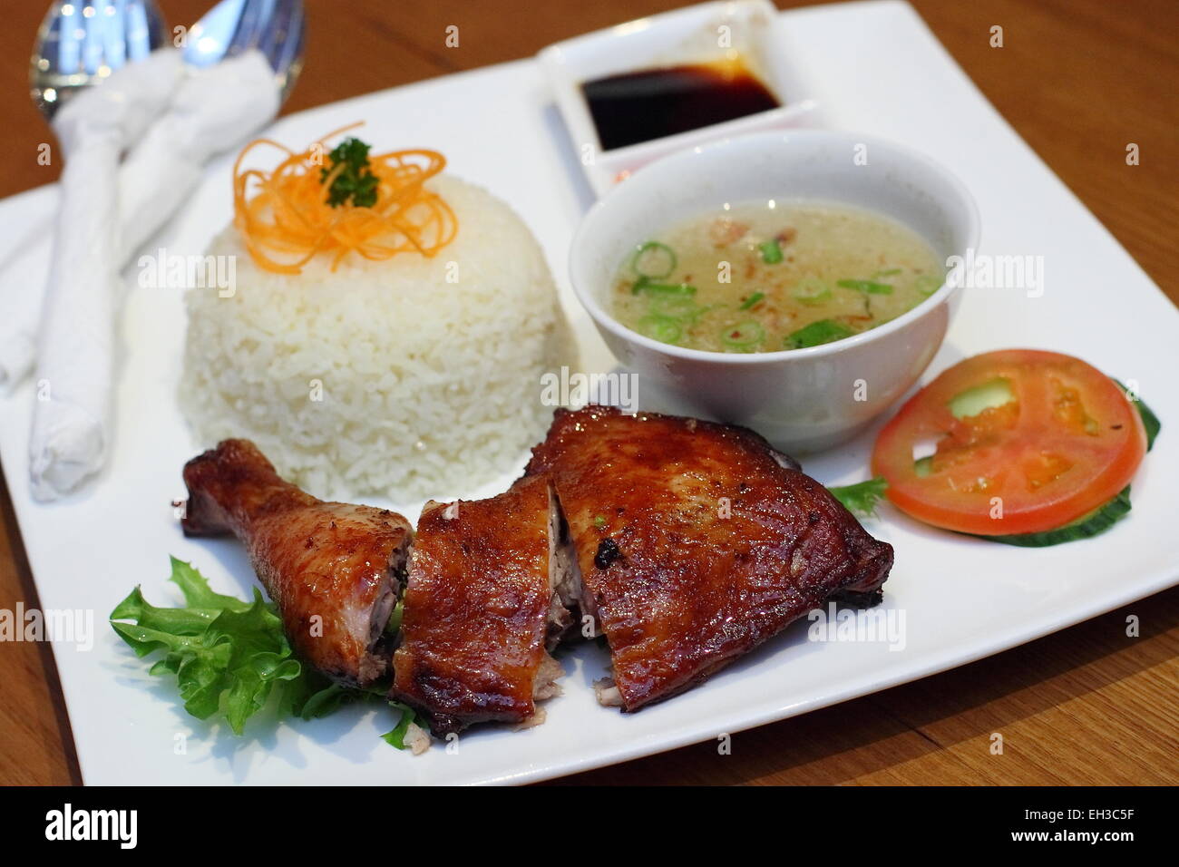 Chicken Rice with Roast Chicken and broth on a white Plate Stock Photo