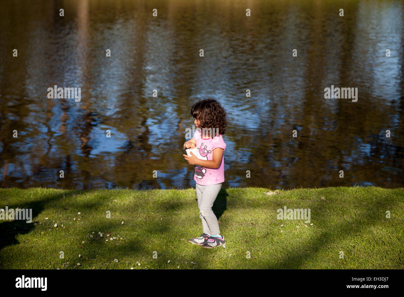 Little girl playing by the pond, Novato, California, USA Stock Photo