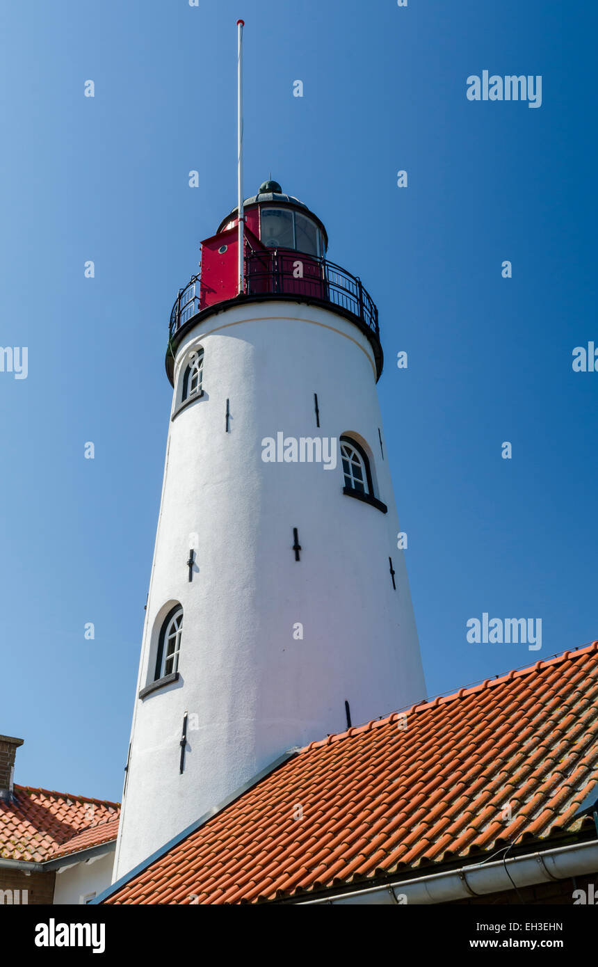 White and red lighthouse (tower) of Urk with in front some houses , Flevoland, The Netherlands Stock Photo