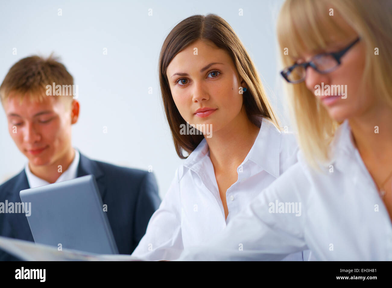 Portrait Of Young Serious Working Woman With Her Colleagues Stock Photo 