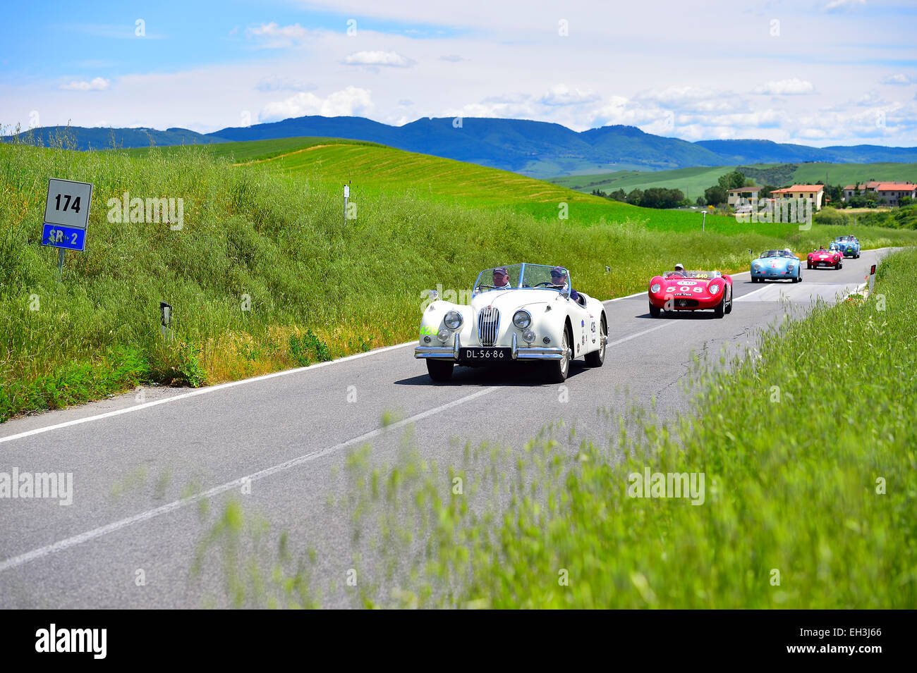 Vintage cars, a Jaguar, 1956, at the front, on road in convoy, Mille Miglia, 1000 Miglia 2014, San Quirico d'Orcia, Siena Stock Photo