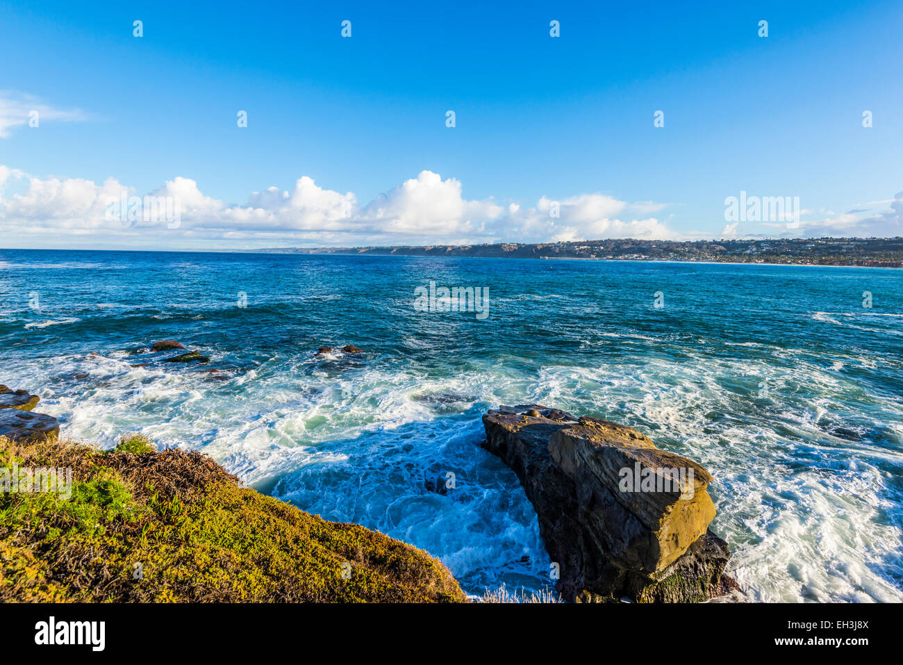 Ocean and rocks. View of the La Jolla coastline in the background. La Jolla, California, United States. Stock Photo