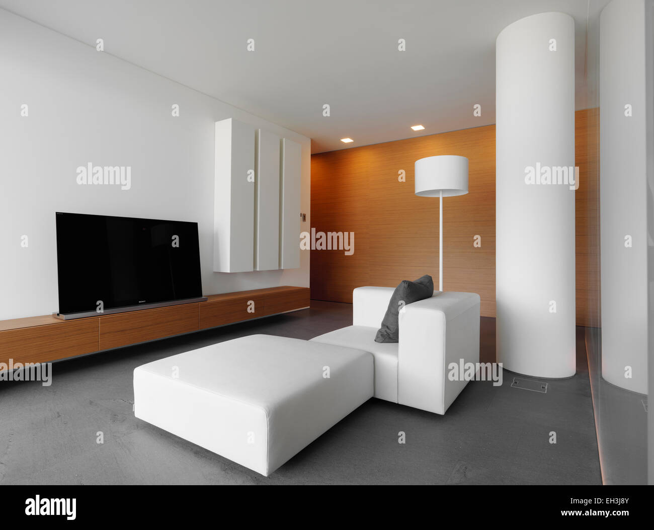 white leather sofa for a modern living room and wood paneling Stock