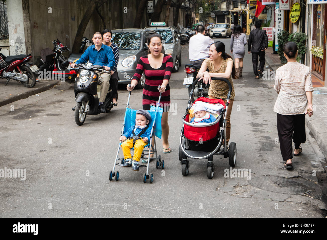Two women,mothers with prams, pushing prams of their babies, children