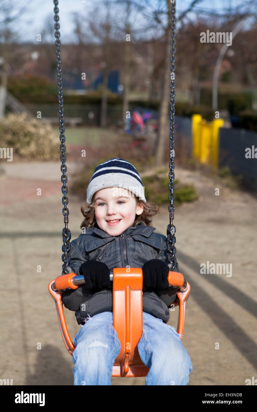 Toddler on a swing in a playground Stock Photo