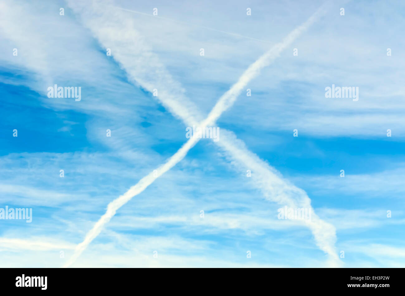 Contrails have formed in the sky after two airplanes have crossed Stock