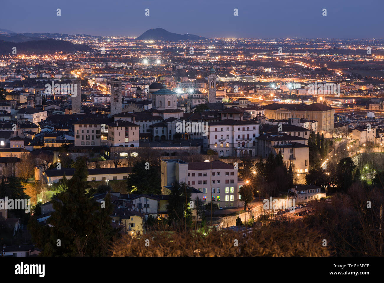 Bergamo, Italy - Aerial view of the old medieval city (Città Alta) and lower Bergamo at night. Stock Photo