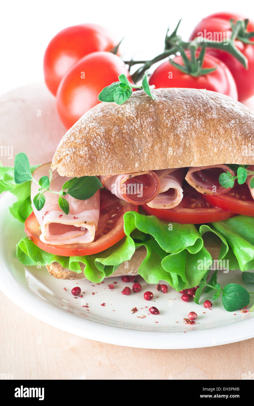 Ciabatta sandwich with ham, tomato and lettuce. Stock Photo