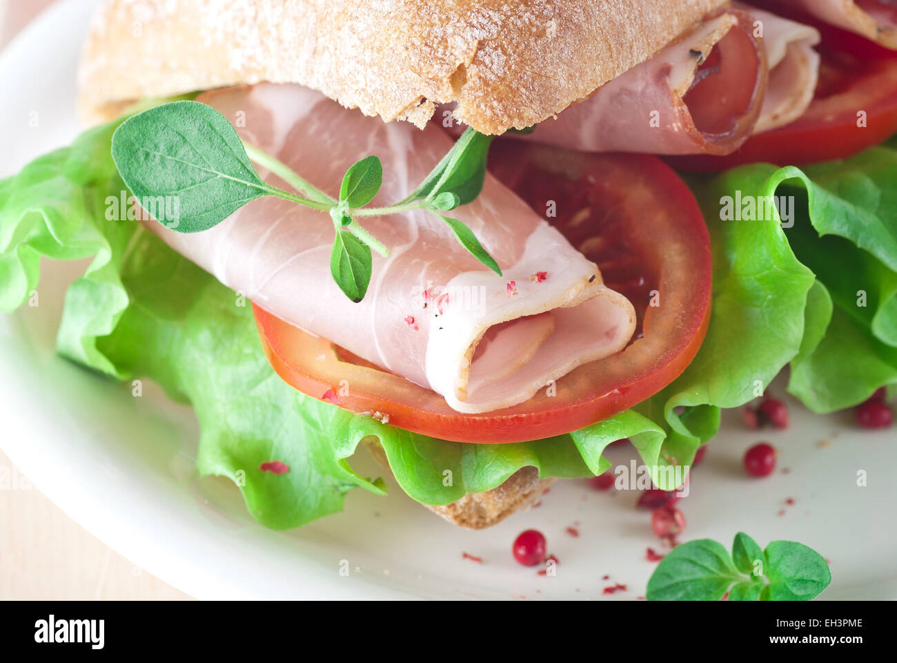 Ciabatta sandwich with ham, tomato and lettuce. Stock Photo