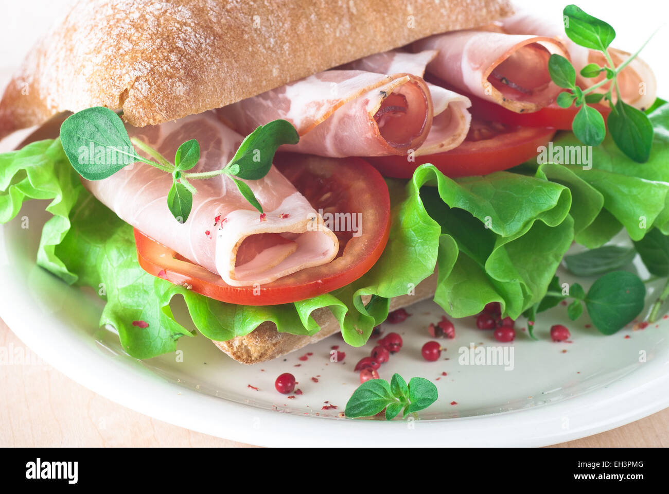 Ciabatta sandwich with ham, tomato and lettuce. Stock Photo