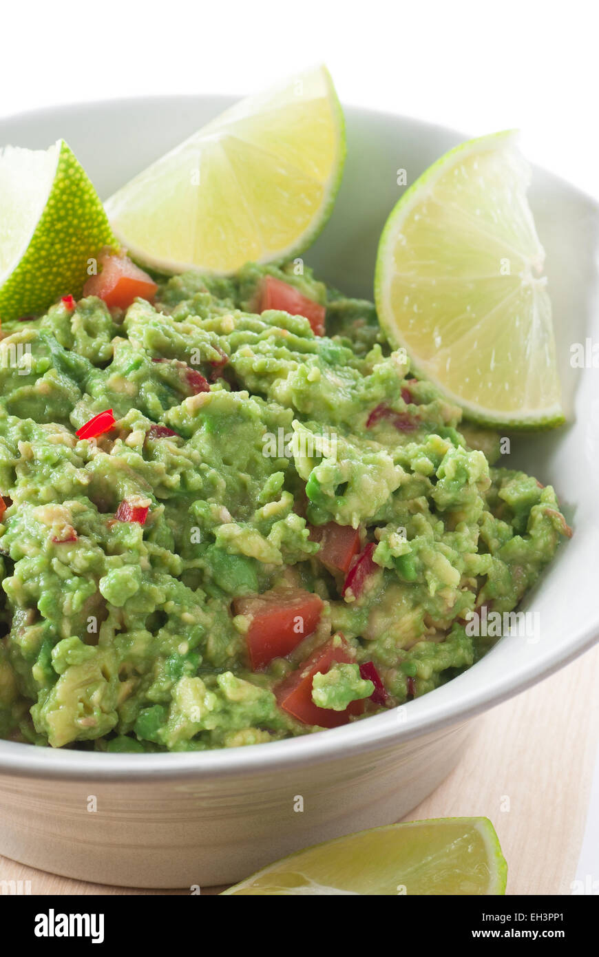 Guacamole in a bowl with lime as garnish. Stock Photo