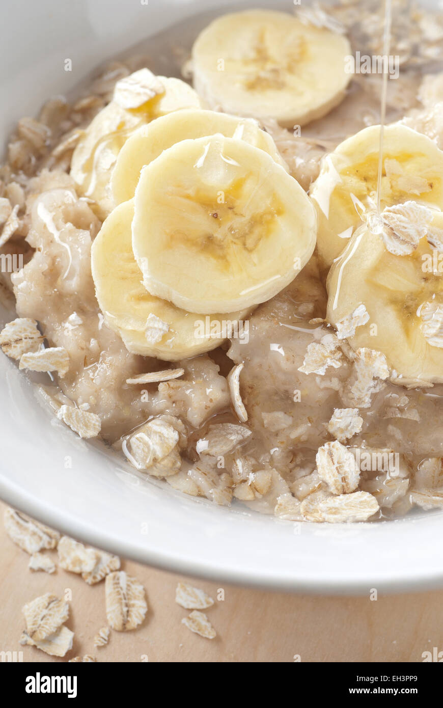 A bowl of oatmeal porridge with sliced banana. Stock Photo