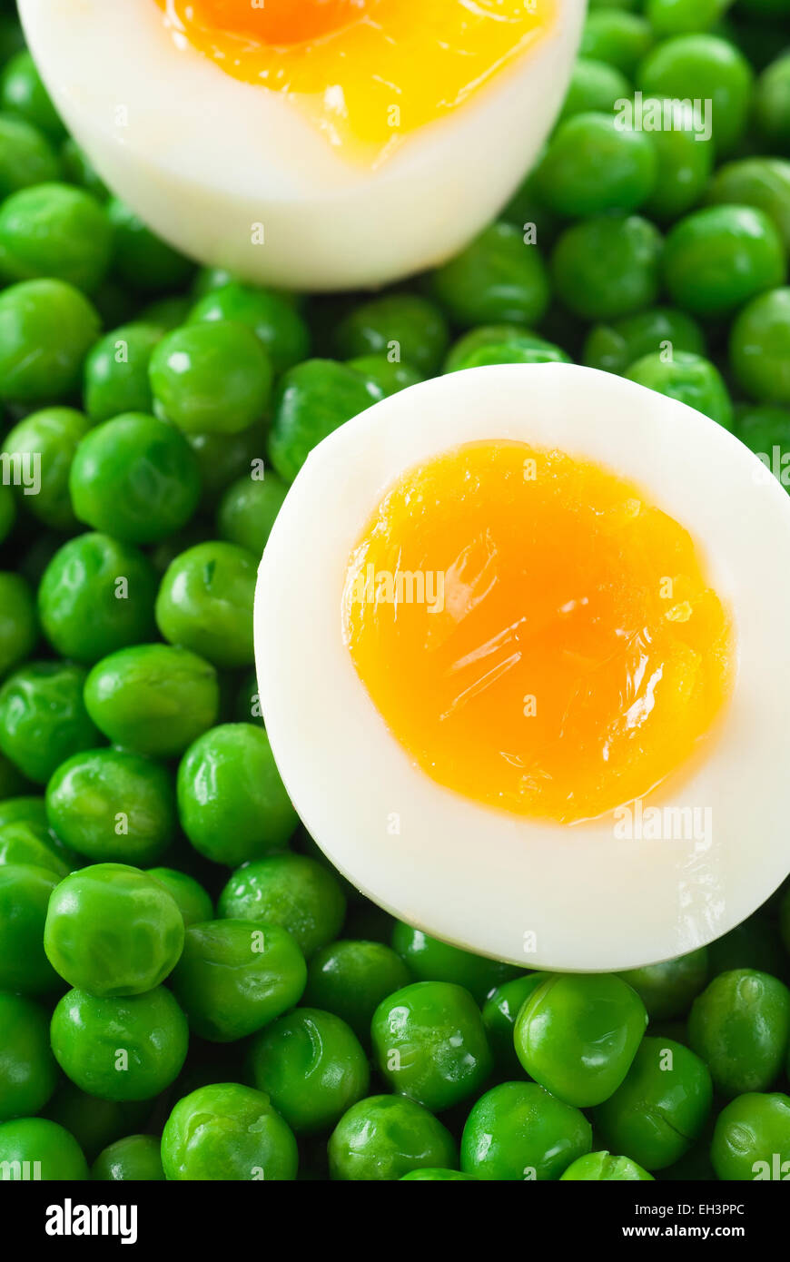 Egg halves on green peas. Stock Photo
