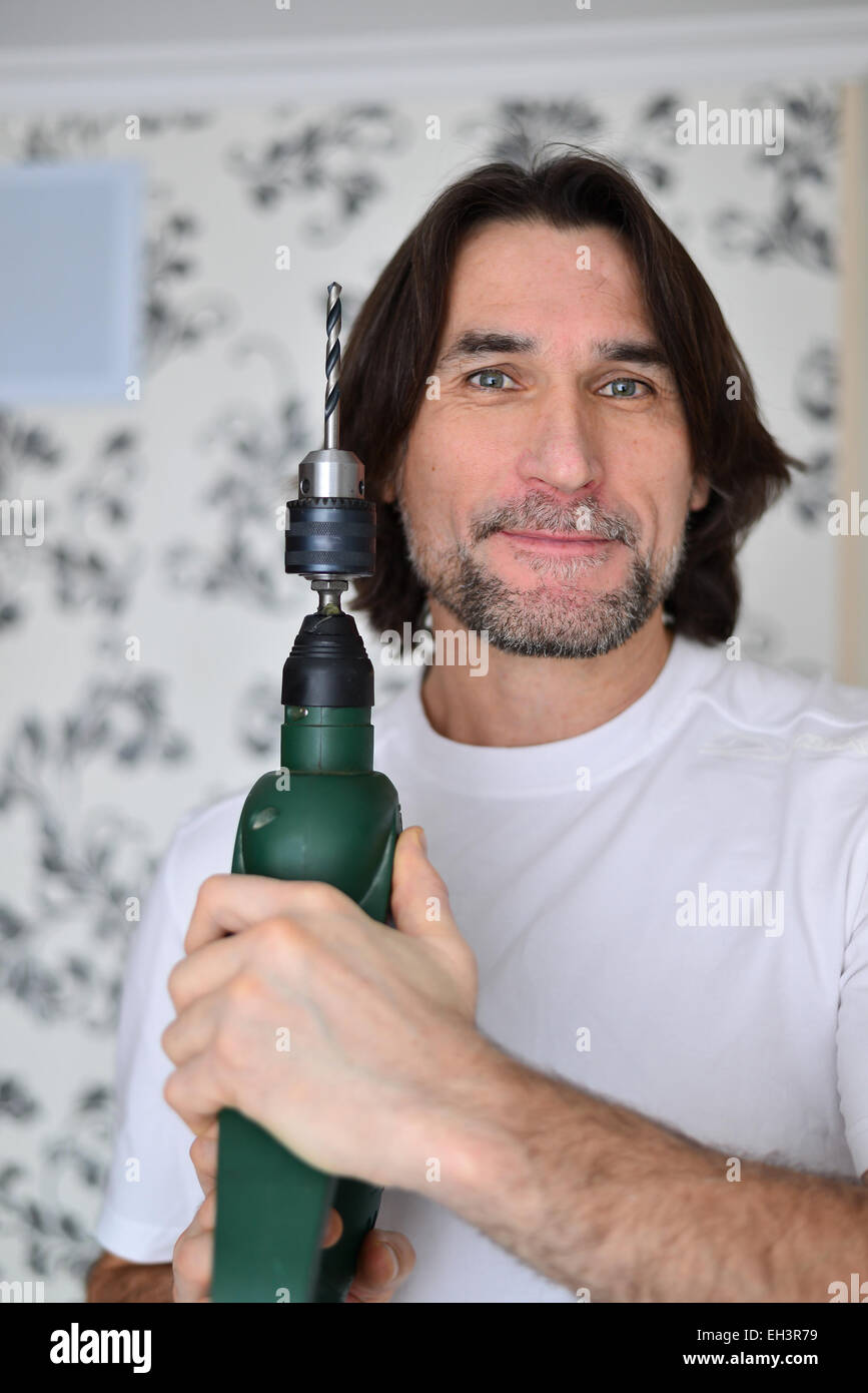 middle-aged man with a drill in the hands of Stock Photo