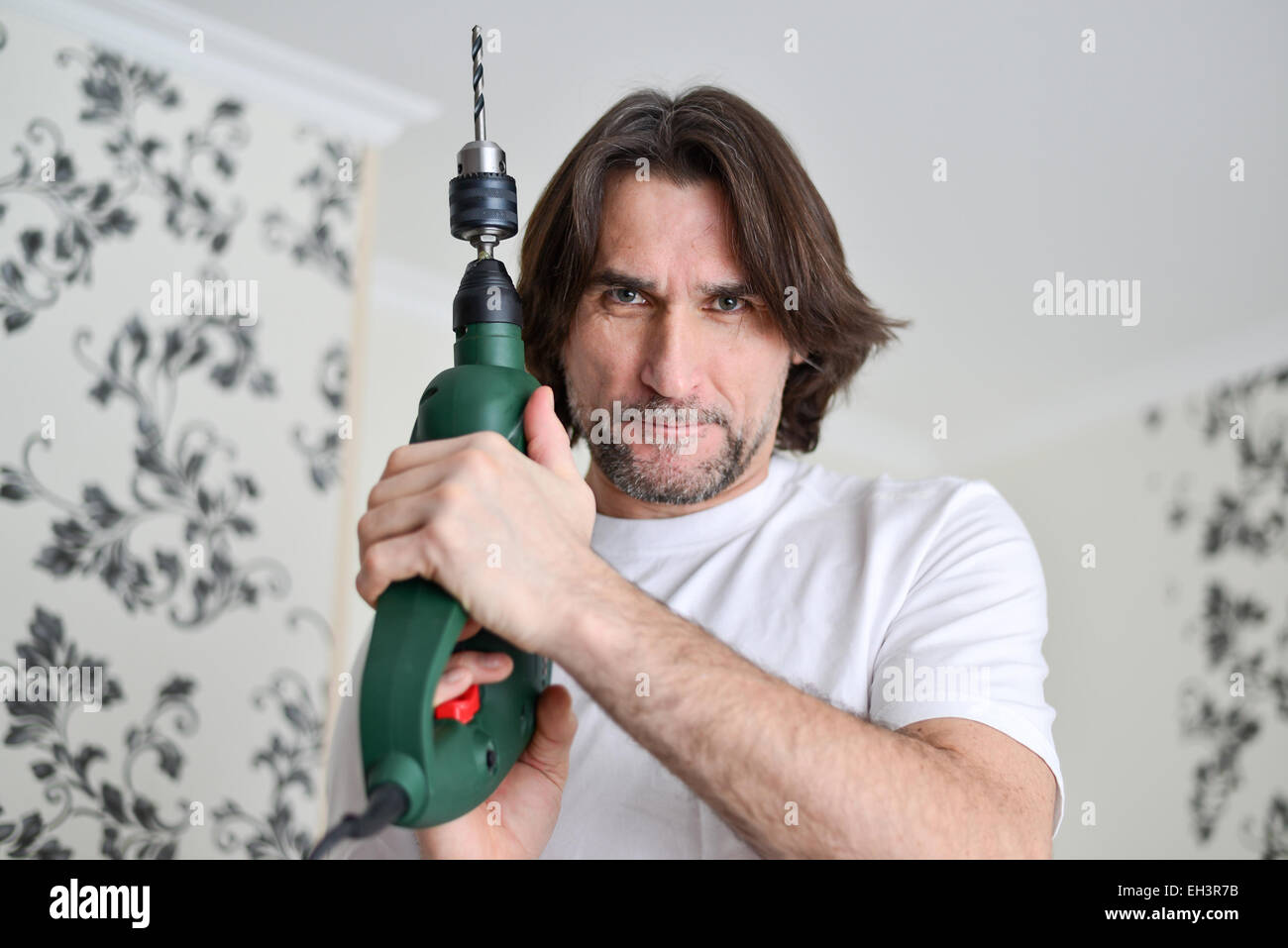 middle-aged man with a drill in the hands of Stock Photo