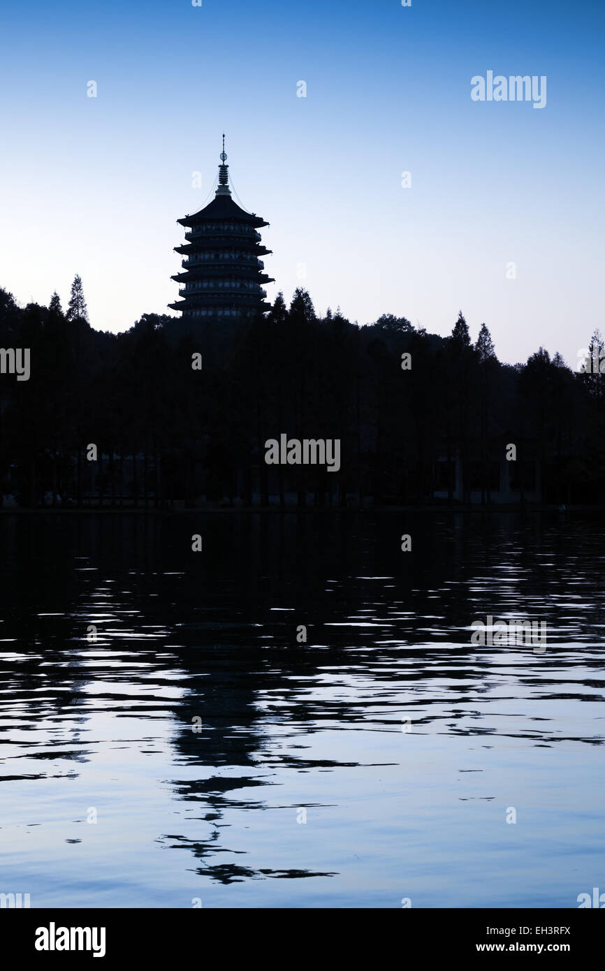 Black silhouette of traditional Chinese pagoda on dark blue evening sky background. Coast of West Lake. Famous park in Hangzhou Stock Photo