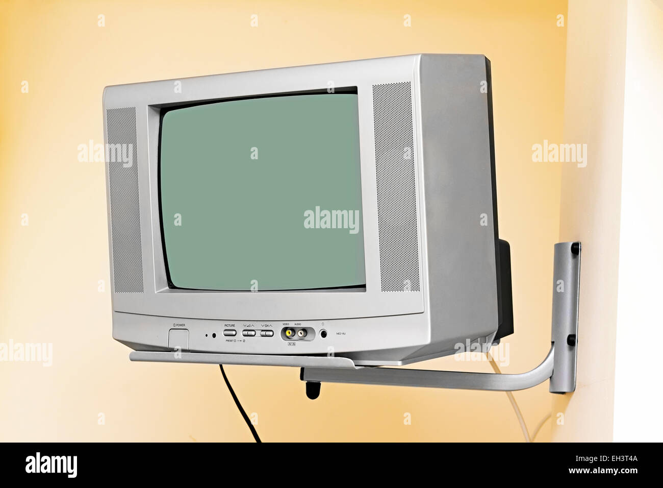 old small TV mounted on wall bracket Stock Photo