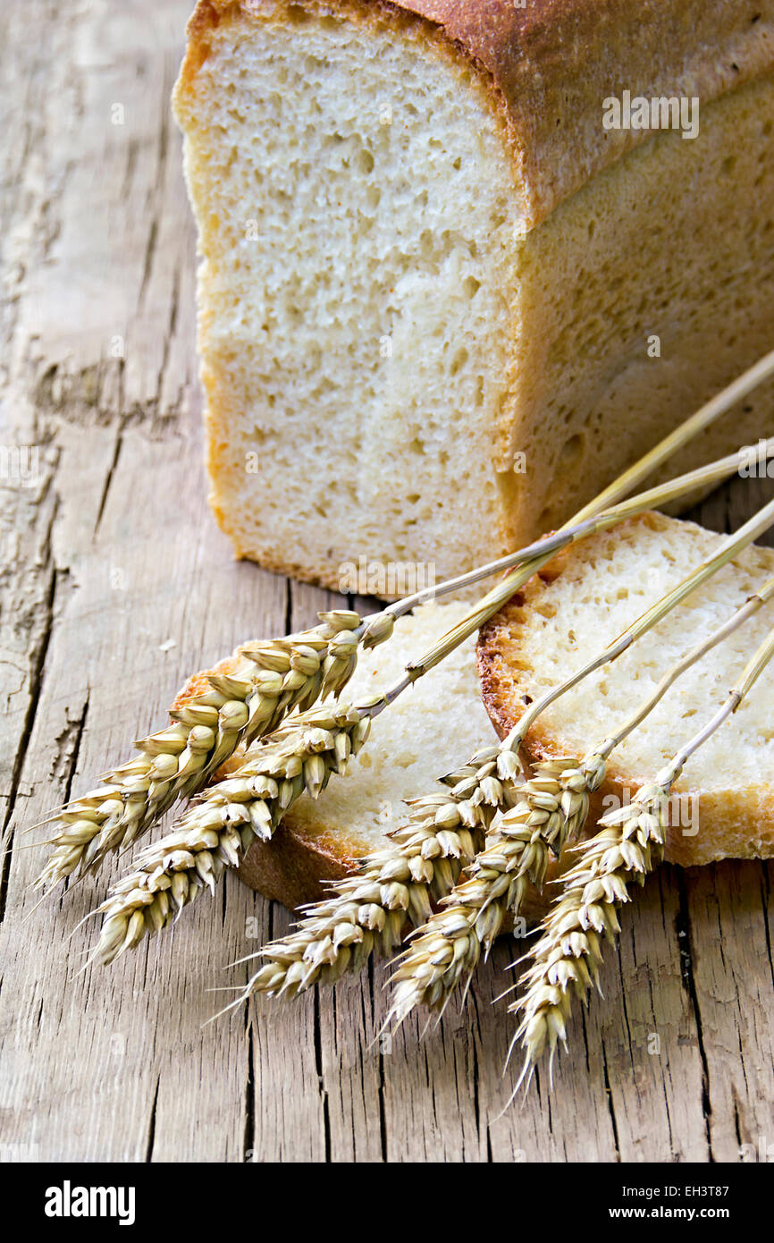 a loaf of bread and wheat ears in the background Stock Photo - Alamy