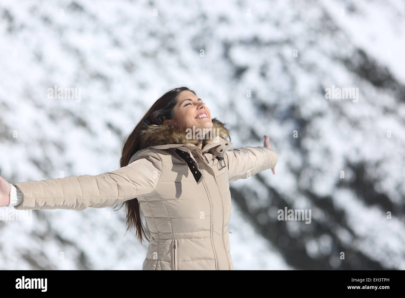 Fashion woman breathing fresh air in a snowy mountain in winter holidays Stock Photo