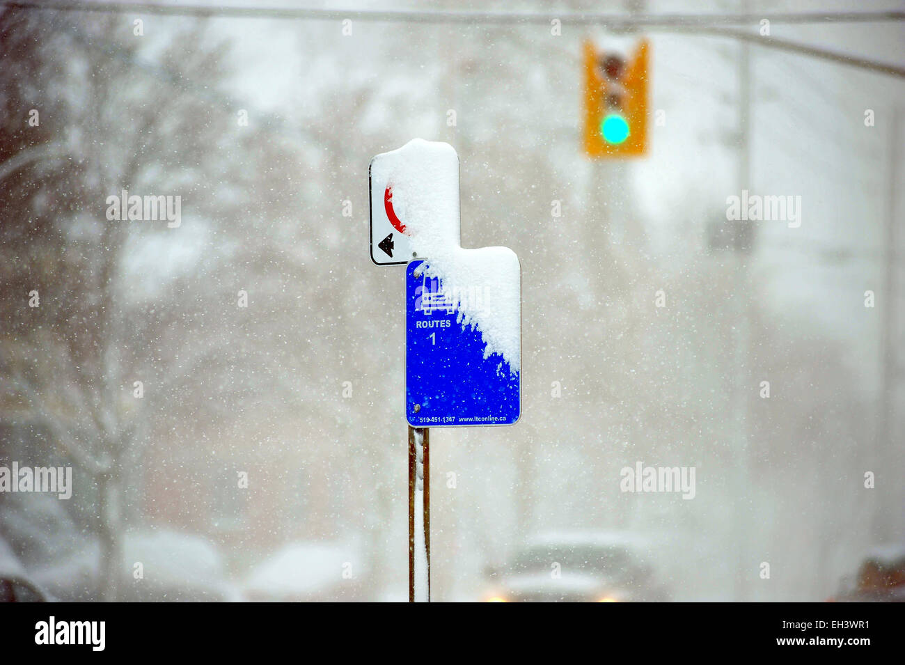 A bus stop sign is obscured by snow in London, Ontario in Canada. Stock Photo