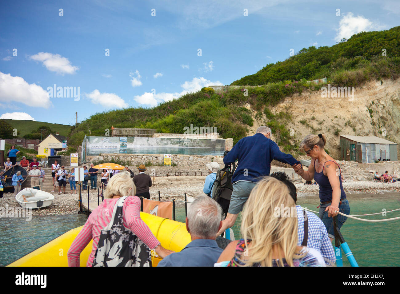 Passengers disembark at the end of a fast RIB ride from Lulworth to Durdle Door on the Jurassic Coast, Dorset, England, UK Stock Photo
