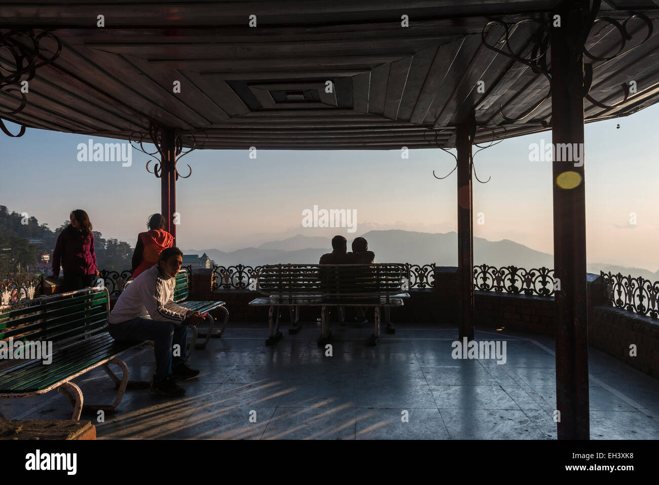 Young Indians enjoying the sunset view over the town of Shimla, Himachal Pradesh, India Stock Photo