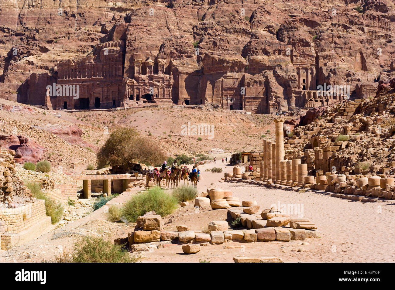 PETRA,  JORDAN - OCT 12, 2014: Roman pillars on colonnaded street, and the 'Royal tombs' on the background in the rocks in Petra Stock Photo