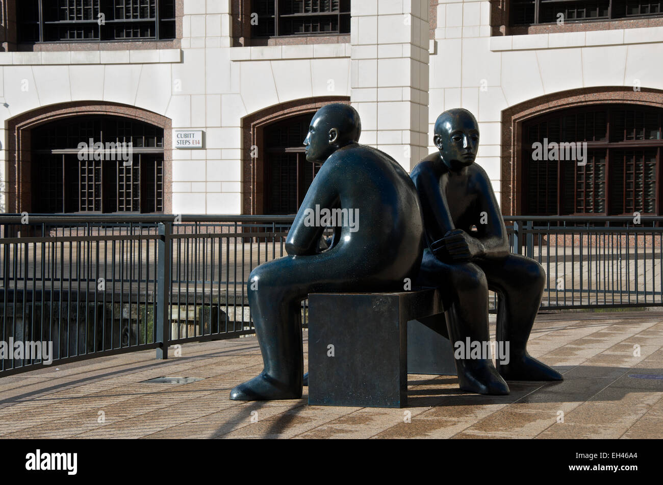 Sculpture of two figures on a bench facing in opposite directions Stock