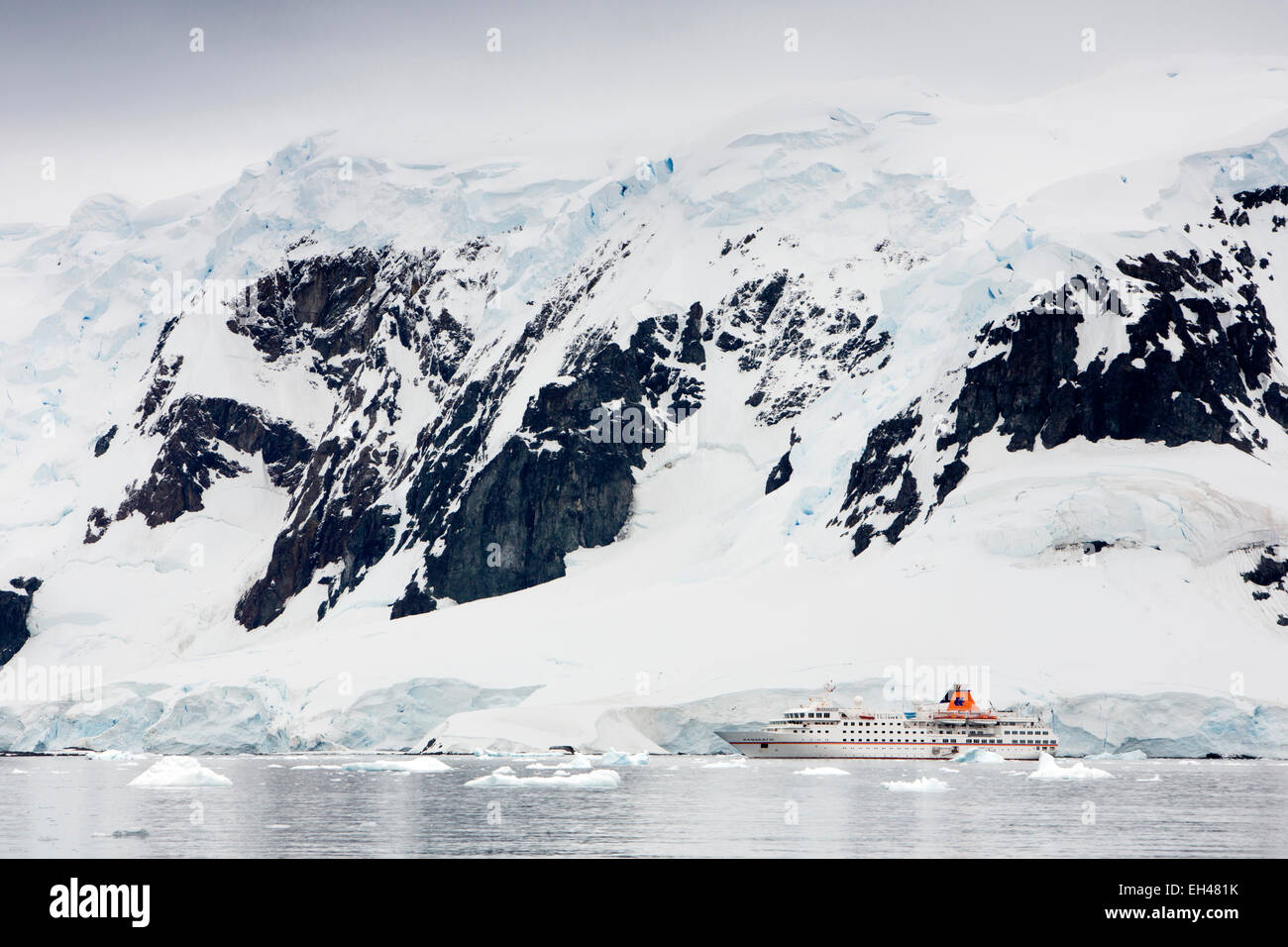 Antarctica, Paradise Bay, MS Hanseatic cruise ship moored below snow capped peaks Stock Photo