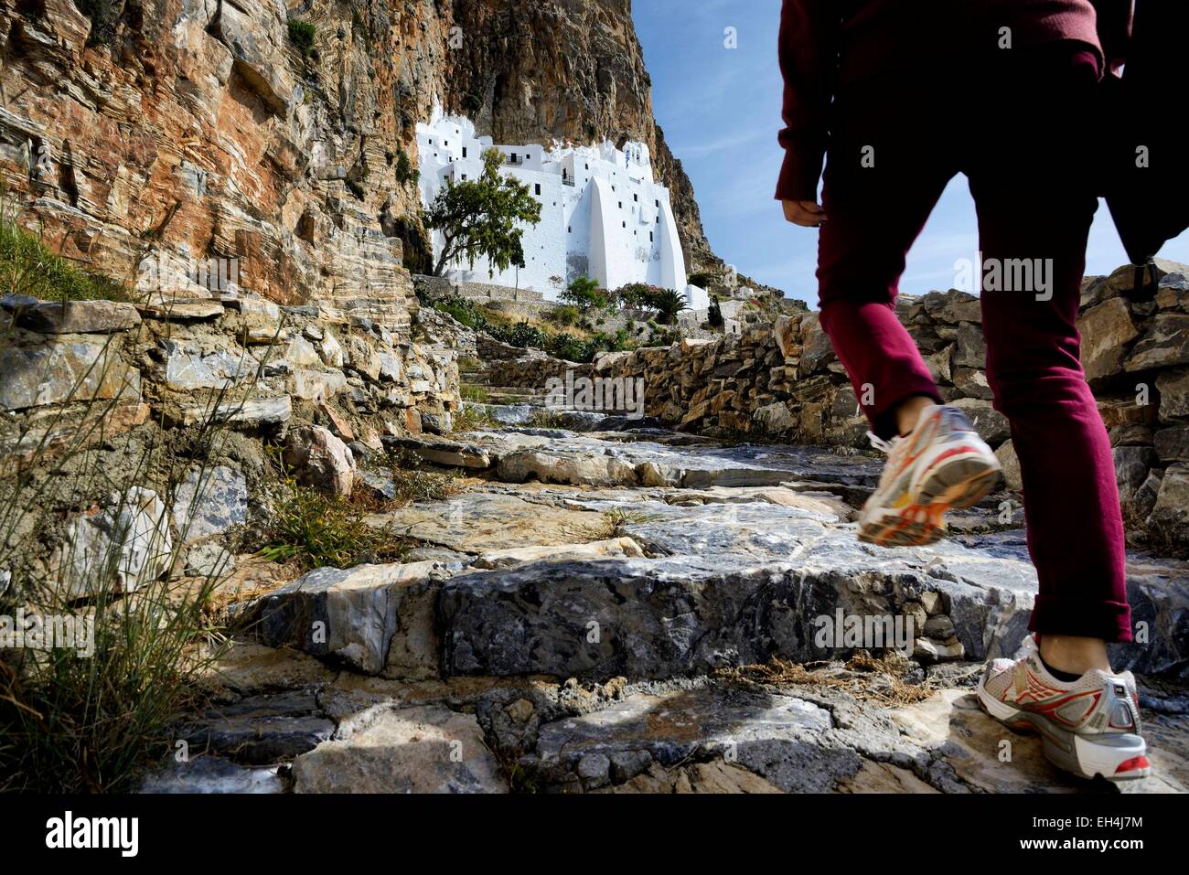 Greece, Cyclades, Amorgos island, woman's leg climbing up the trail to the monastery of Panagia Hozoviotissa (Moni Hozoviotissis, Chozoviotissa) Stock Photo