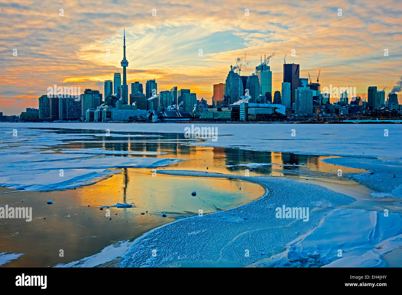 Dramatic sky at Toronto;Capital City of Ontario;Canada in the winter of 2015; Harbor with ice and snow and boats and CN tower Stock Photo