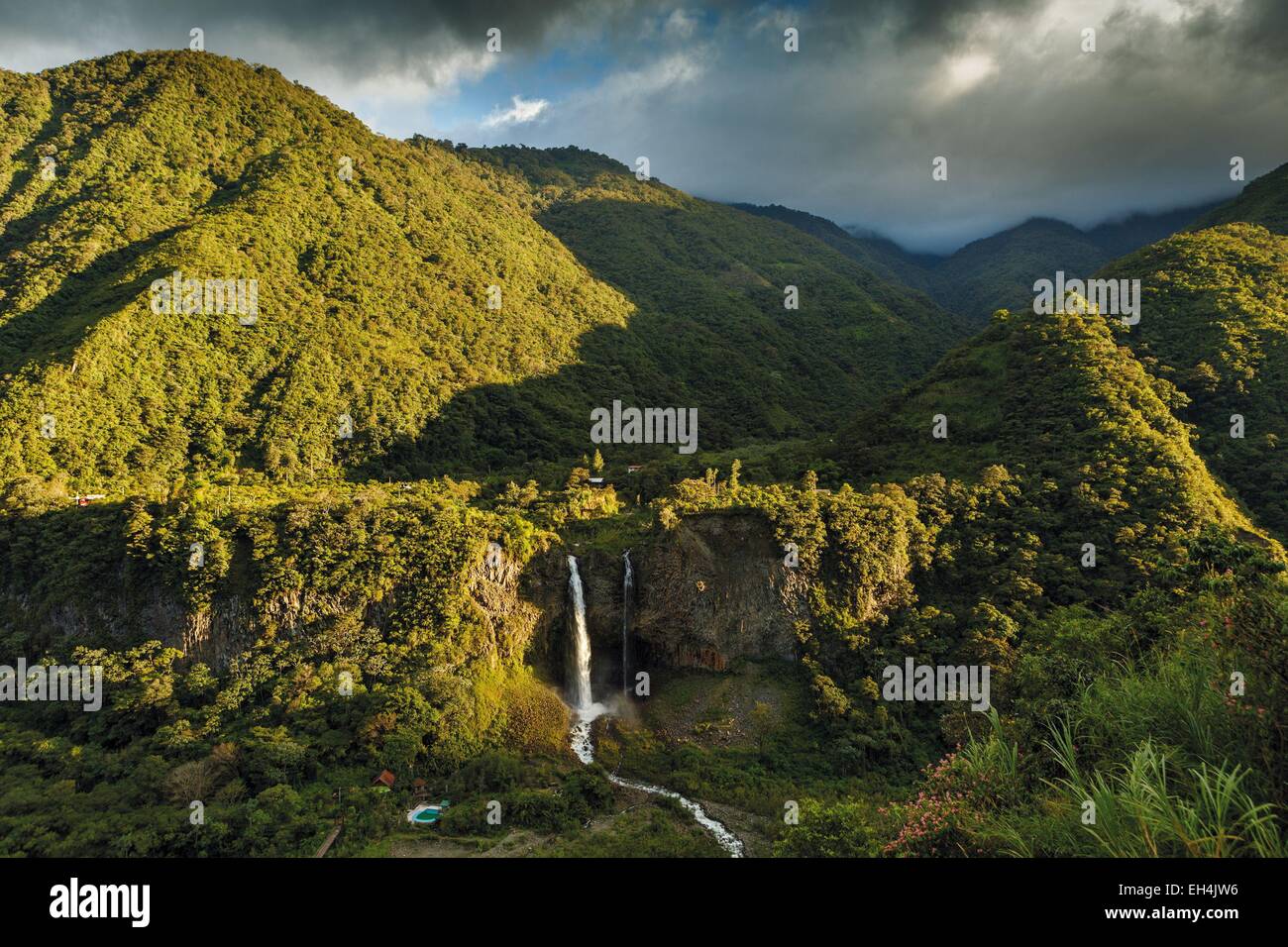 Ecuador, Tungurahua, Banos de Agua Santa, mountainous landscape with a waterfall in a tropical greenery caskets at sunset on a stormy sky Stock Photo